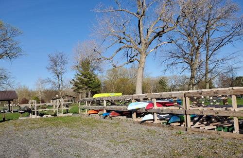 wooden kayak storage rack with different colored kayaks on sunny day early spring