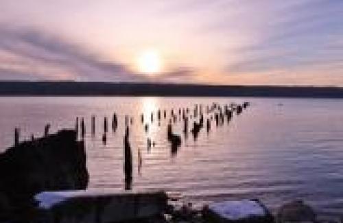 old dock posts in lake offshore of Salt Point during cloudy sunset