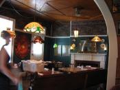 old, classic dining room; wood tables, white fire place, green walls, elaborate wood ceiling