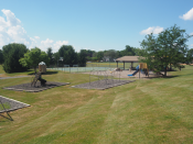 sunny day with far off picture of pavilion on ballfield next to playground